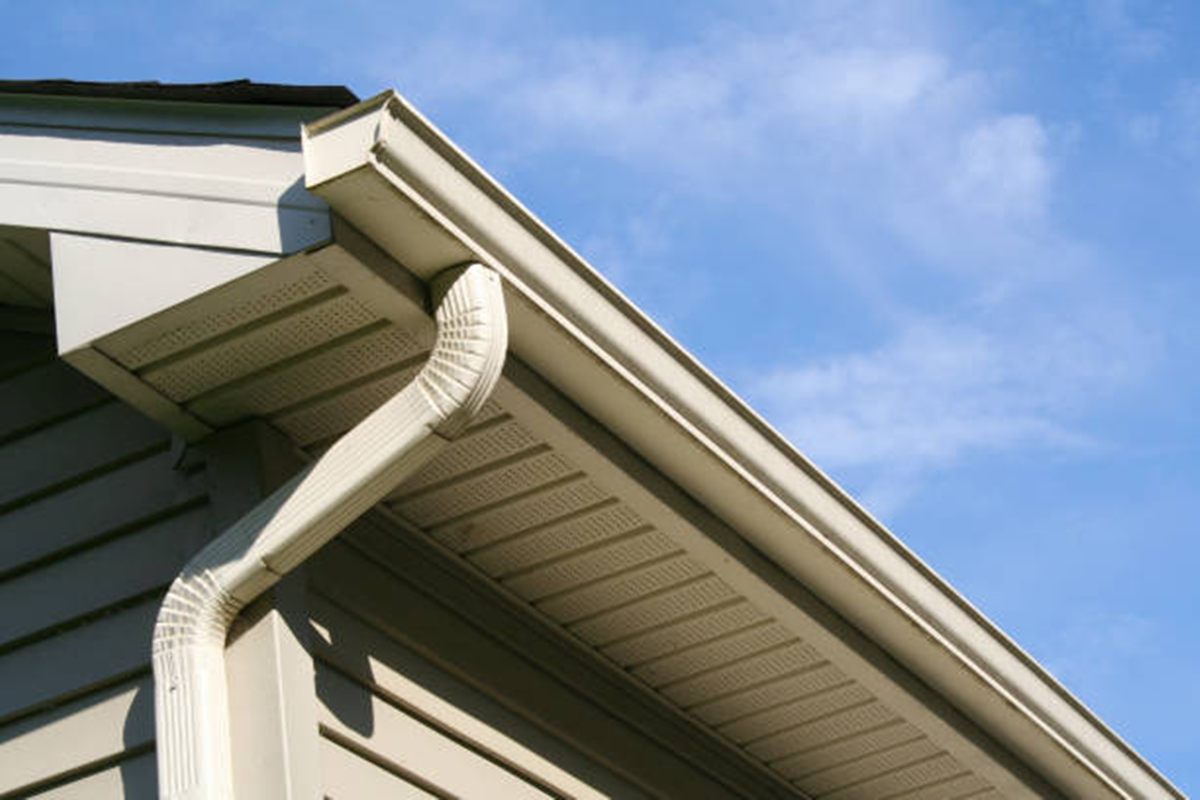 Foto close-up talang air PVC terpasang di sisi atap rumah minimalis tropis.